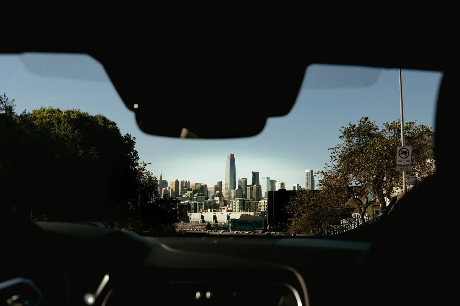 San Francisco skyline viewed through a car windshield, with Salesforce Tower in the center.